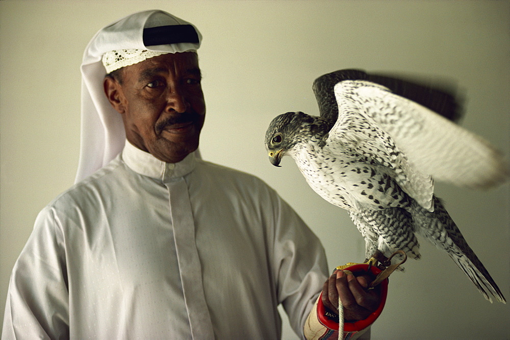 Portrait of falcon handler and Gyr Falcon, Bahrain, Middle East