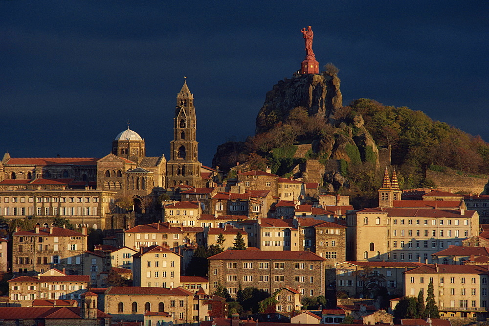 Houses and churches overlooked by a hilltop statue of the Virgin and child at Le Puy, Auvergne, France, Europe