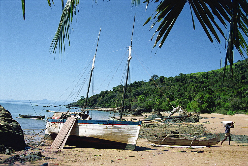 Man unloading rice from boat onto beach, Nosy Komba Island, Madagascar, Africa