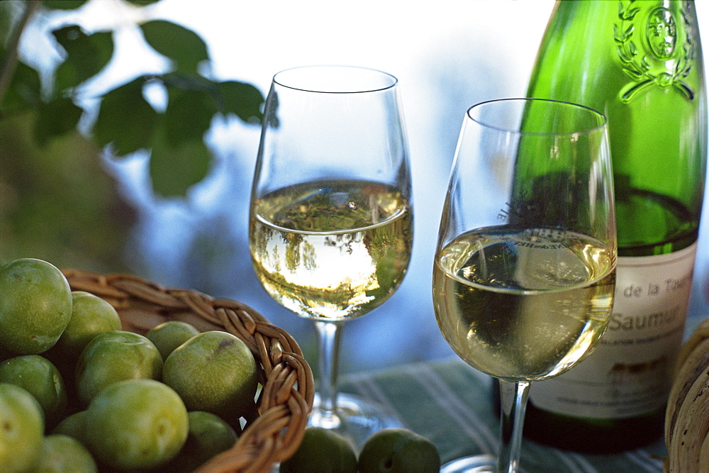 Glasses of white wine on table with river relected in glass, Loire, France, Europe