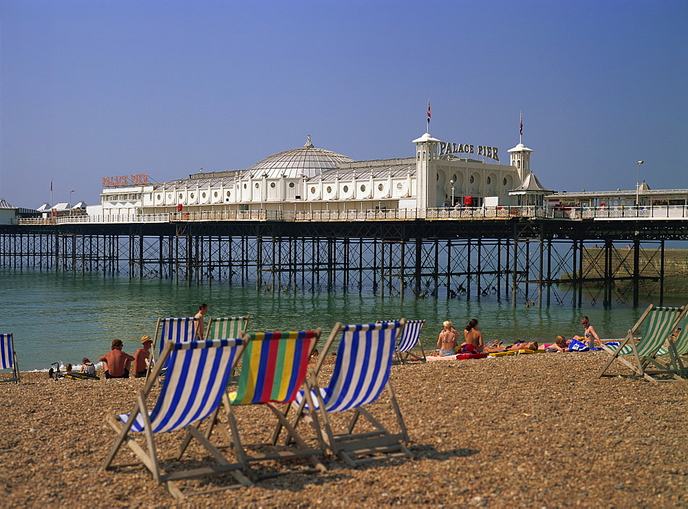 Empty deck chairs on the beach and the Brighton Pier, Brighton, Sussex, England, United Kingdom, Europe