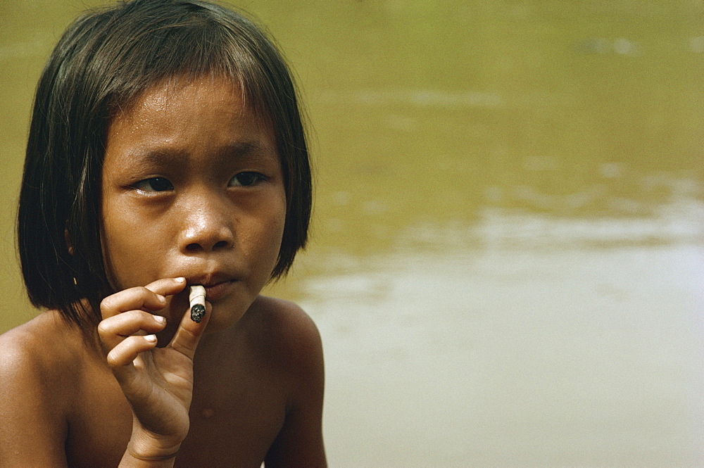 Kayan child smoking, along the Balui River, Sarawak, Malaysia, Southeast Asia, Asia