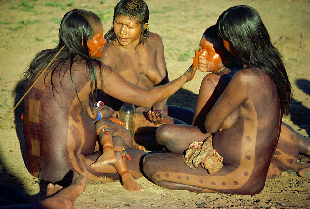 A group of Xingu women applying body paint in Brazil, South America