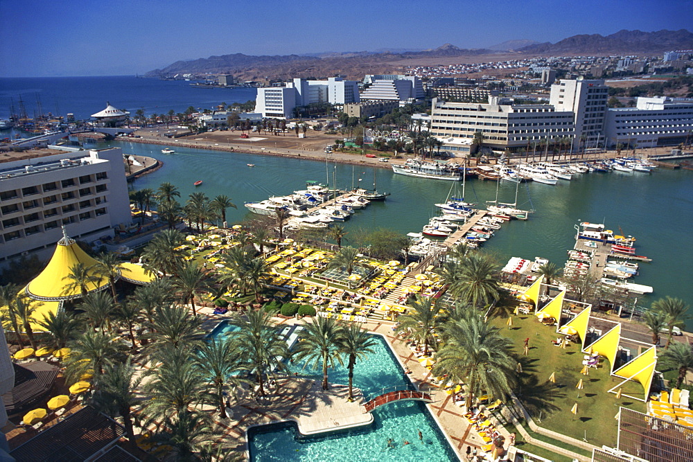 Aerial view over swimming pool, palm trees and the marina at Eilat, with modern buildings in the background, Israel, Middle East