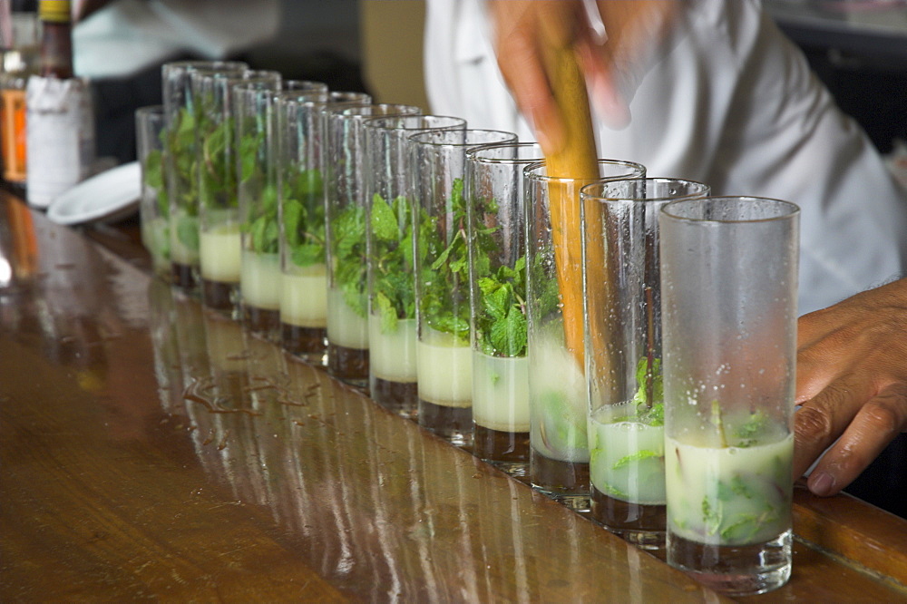 Row of glasses on a bar with barman preparing mojito cocktails, Habana Vieja, Havana, Cuba, West Indies, Central America