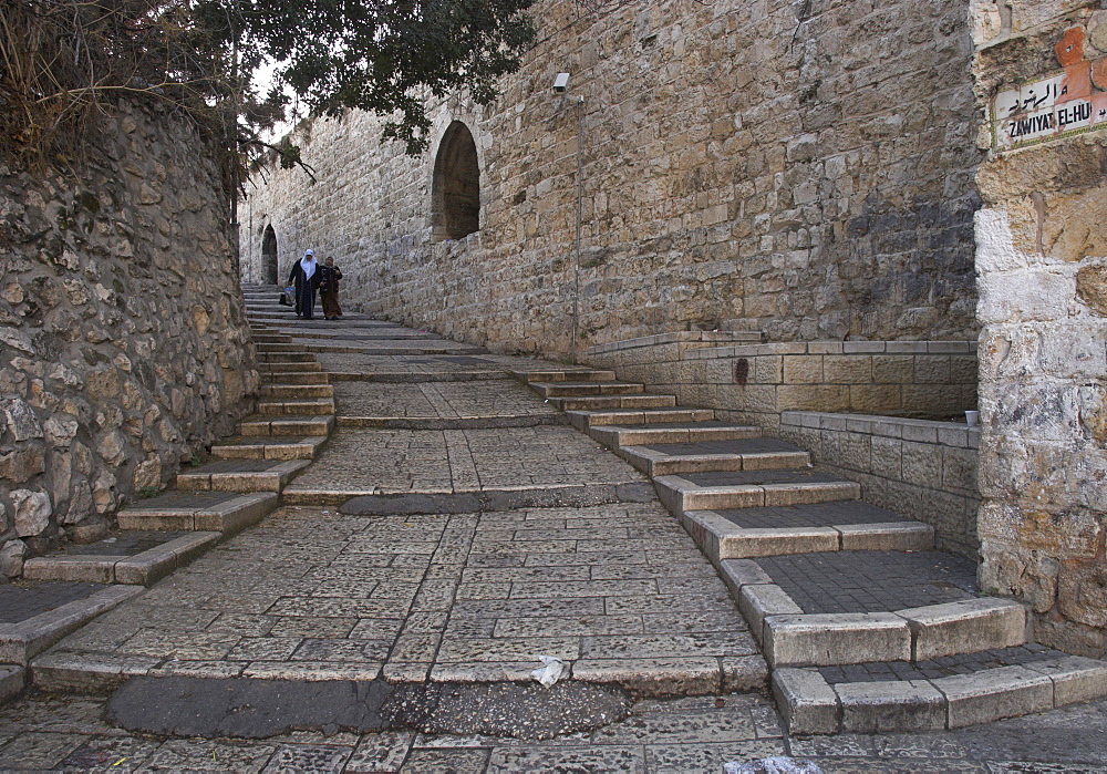 Two Palestinian women walking down a street along the city walls, Old City, Jerusalem, Israel, Middle East