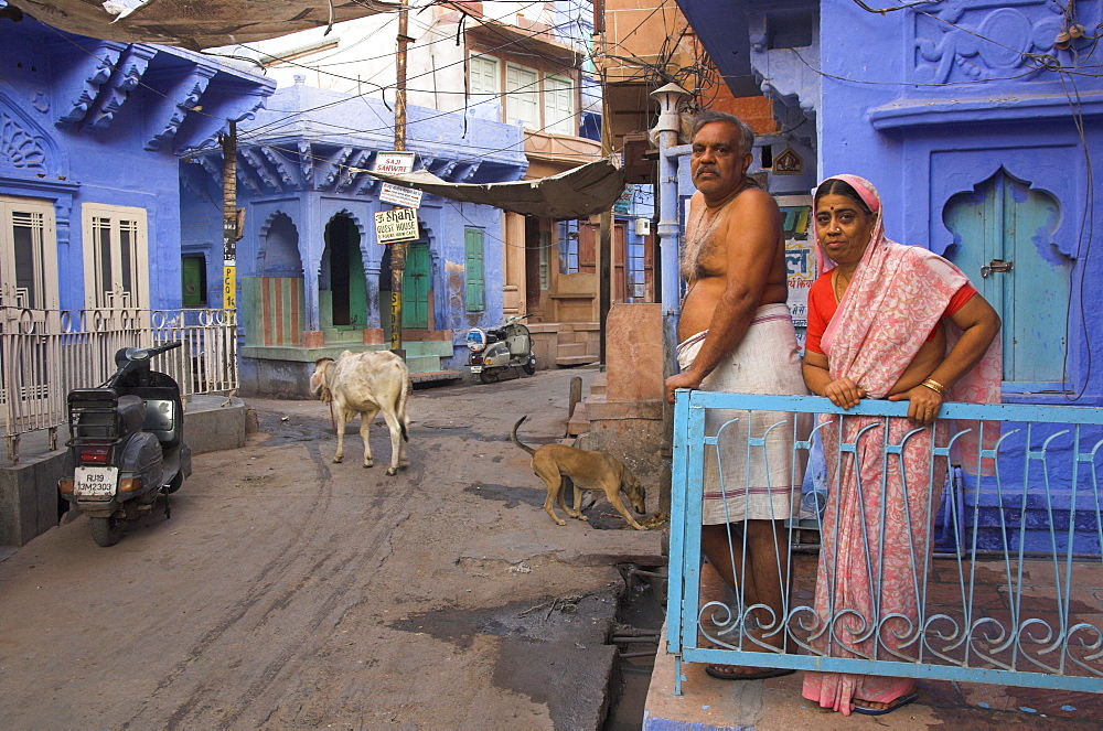 Couple standing outside blue painted residential haveli, Old City, Jodhpur, Rajasthan state, India, Asia