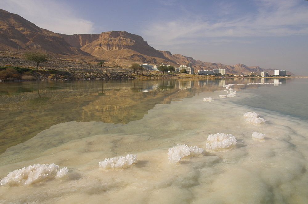 Sea and salt formations with hotels and desert cliffs beyond, Ein Bokek Hotel Resort, Dead Sea, Israel, Middle East