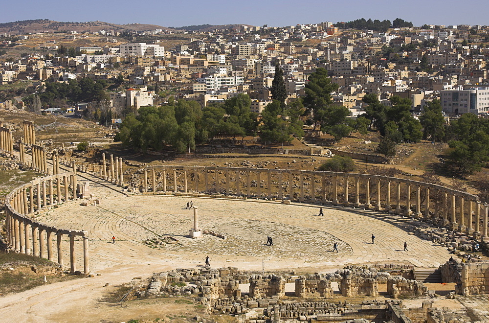 View from above of oval Roman Forum, with Jerash town in background, Jerash, Jordan, Middle East