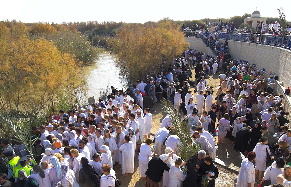 Crowds of pilgrims in white dress queueing to enter the water of the Jordan River during Christian Orthodox ceremony at Epiphany, Qasr el Yahud, Israel, Middle East