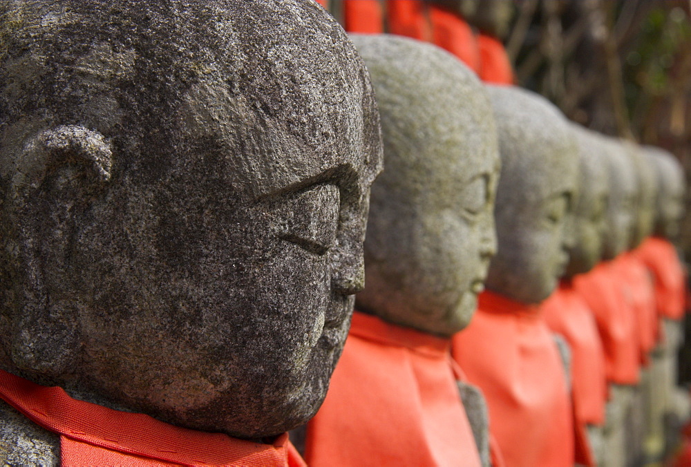 Close up of a row of stone figures wearing red cloth, Sanzen In shrine, Kyoto, Kansai, Honshu, Japan, Asia