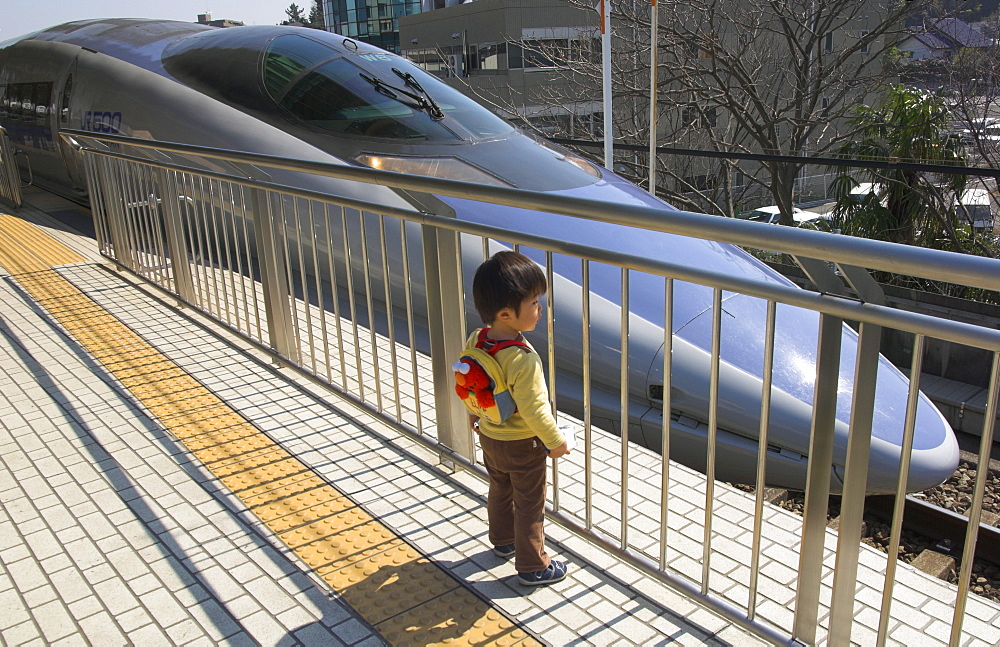 Young child on platform looking at train, Shin Yokohama Shinkansen station, Kansai, Honshu, Japan, Asia