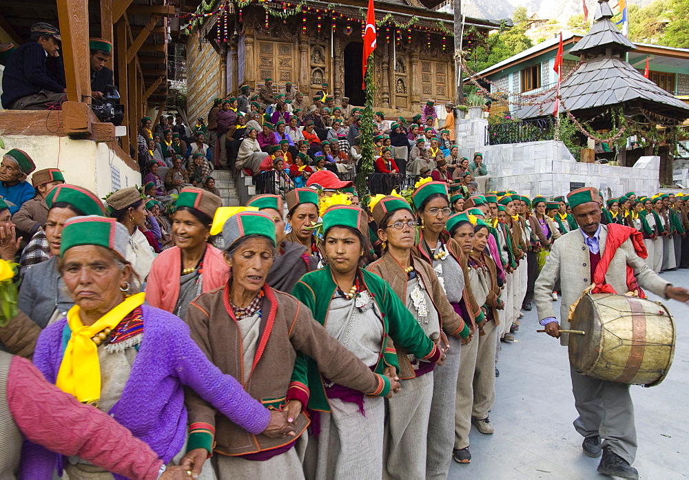 Group of women in full traditional clothes performing traditional dancing in a row with man beating on drum during Ataro religious festival in Baring Narj temple, Sangla, Baspa Valley, Kinnaur, Himachal Pradesh, India, Asia