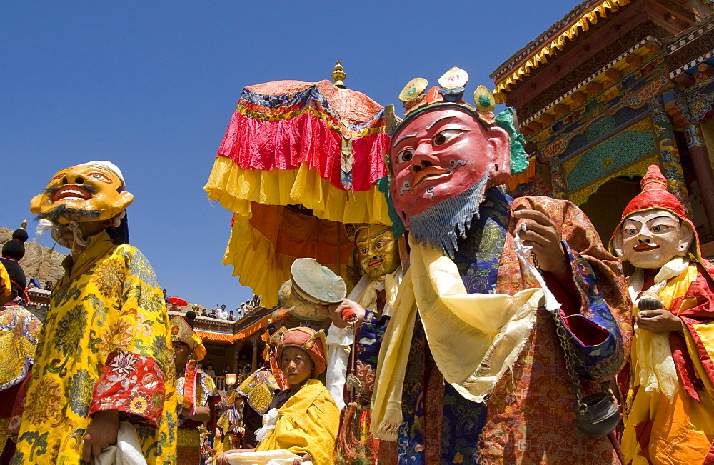 Group of monks in wooden masks and traditional costumes in procession in the monastery courtyard, Hemis Festival, Hemis, Ladakh, India, Asia