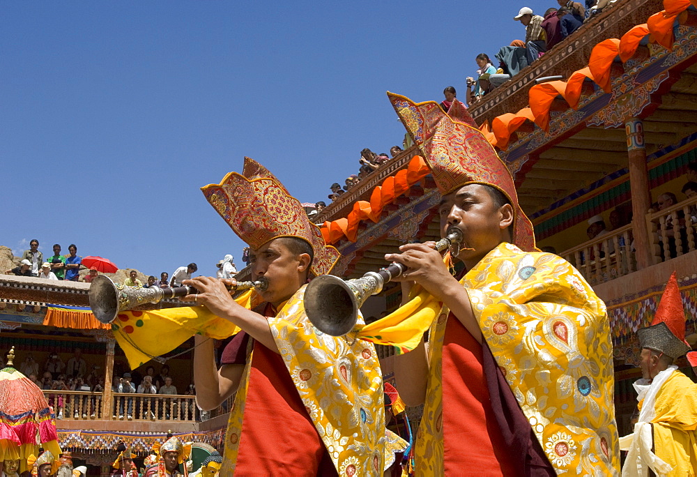 Procession in monastery courtyard with monk musicians blowing traditional horns, Hemis Festival, Hemis, Ladakh, India, Asia