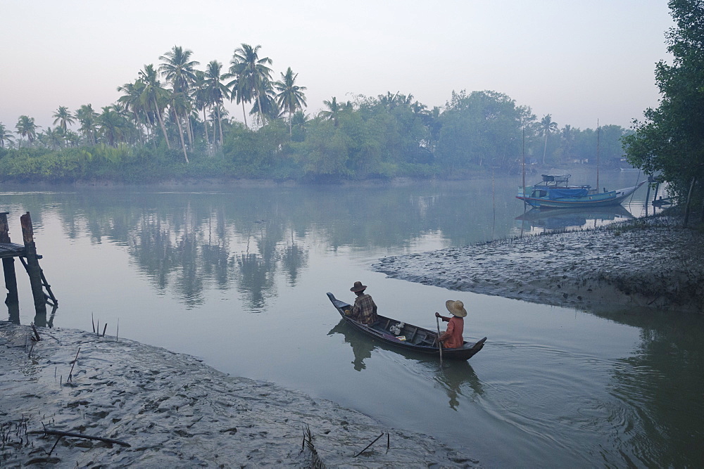 Two women on a small boat in early morning light, Oak Po Kwin Chaung village, Irrawaddy Delta, Myanmar (Burma), Asia