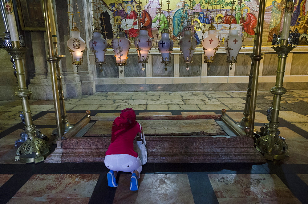 Woman prostrating at the Stone of Anointing. Holy Sepulchre. Jerusalem Old City, Israel, Middle East