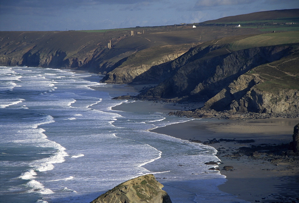 Surf and tin mine chimneys in distance, Porthtowan, Cornwall, England, United Kingdom, Europe