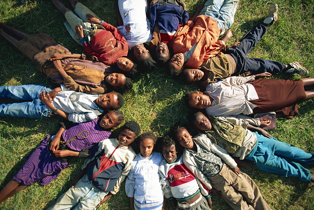 Street kids lying in star formation, Addis Ababa, Ethiopia, Africa