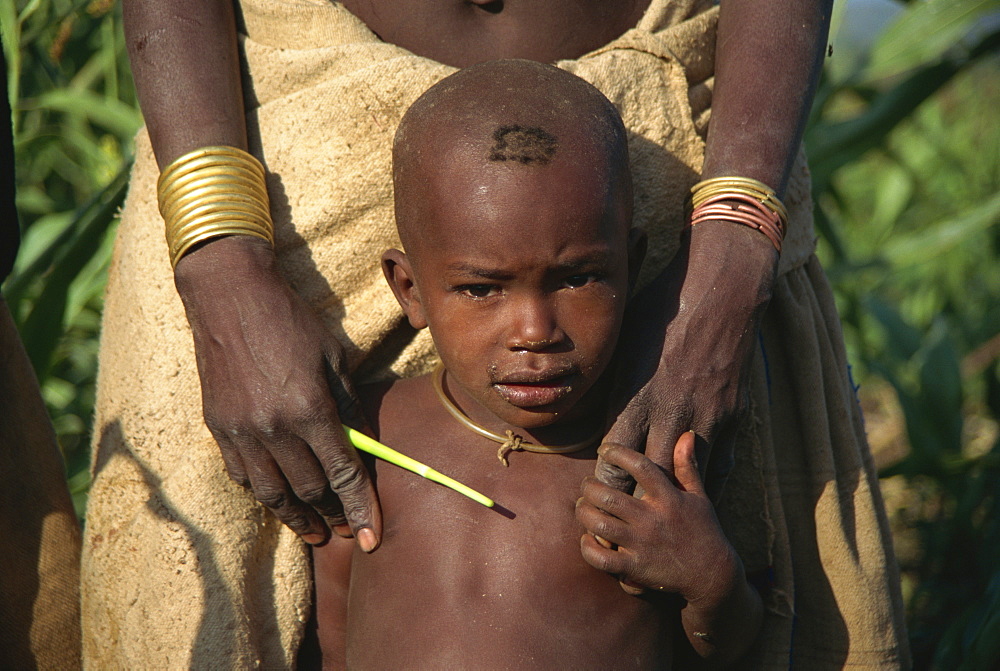 Boy stays close to his mother, Konso, Ethiopia, Africa