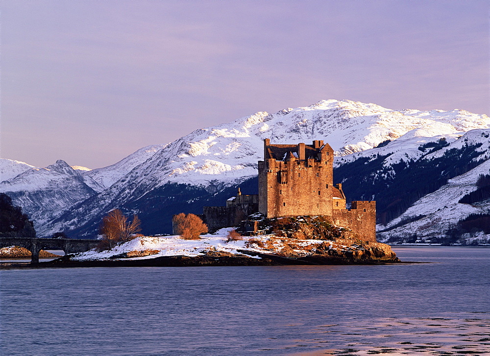 Eilean Donan castle in winter, from Ardelve Point in late afternoon with snow on the mountains round Loch Duich, Dornie, Highlands, Scotland, UK, Europe