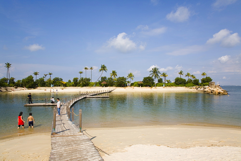 Tropical Siloso beach, sea lagoon and wooden bridge linking small island at western end of southern coast, Sentosa Island, Singapore, Southeast Asia, Asia