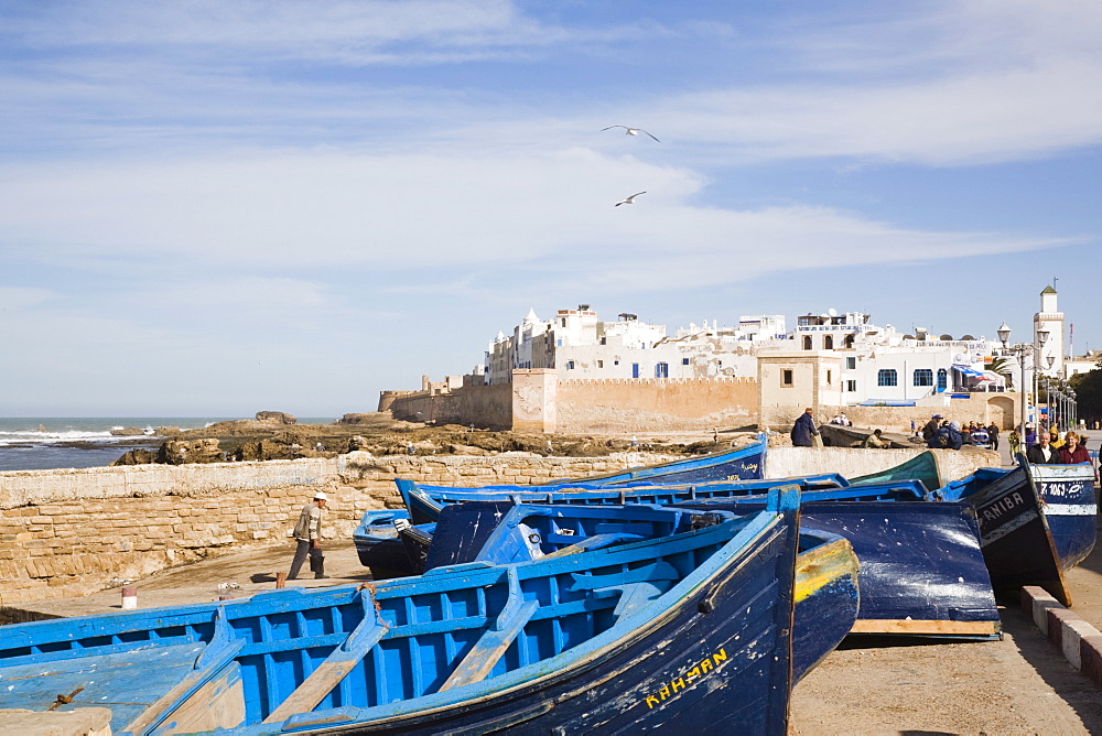 Small wooden fishing boats on seafront with white buildings of the Medina beyond, Essaouira, formerly Mogador, Morocco, North Africa, Africa