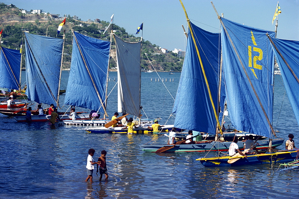 Boats with blue sails line up at the start of a Lakatoi canoe race, Konedobu, Port Moresby, Papua New Guinea, Pacific Islands, Pacific