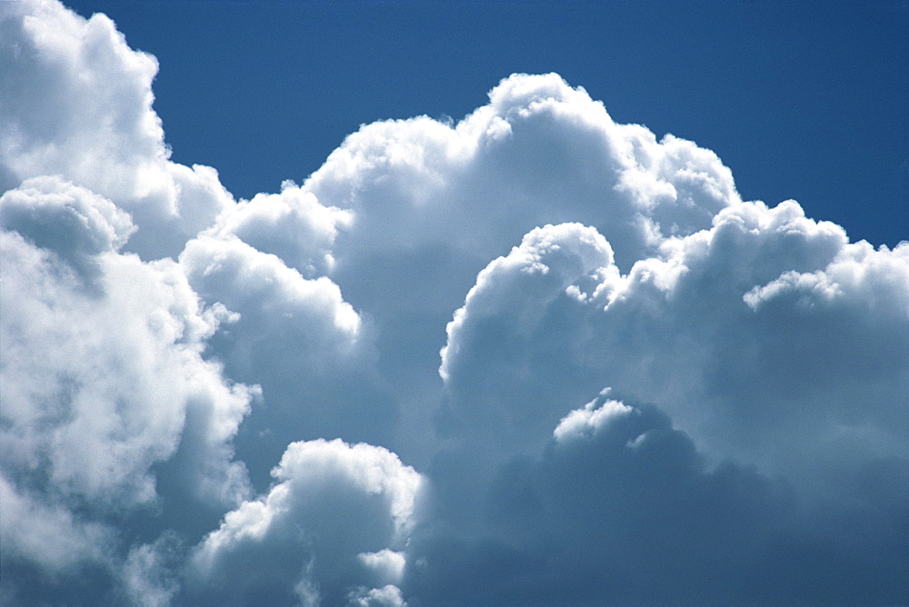 Banks of puffy white clouds tower into a blue sky