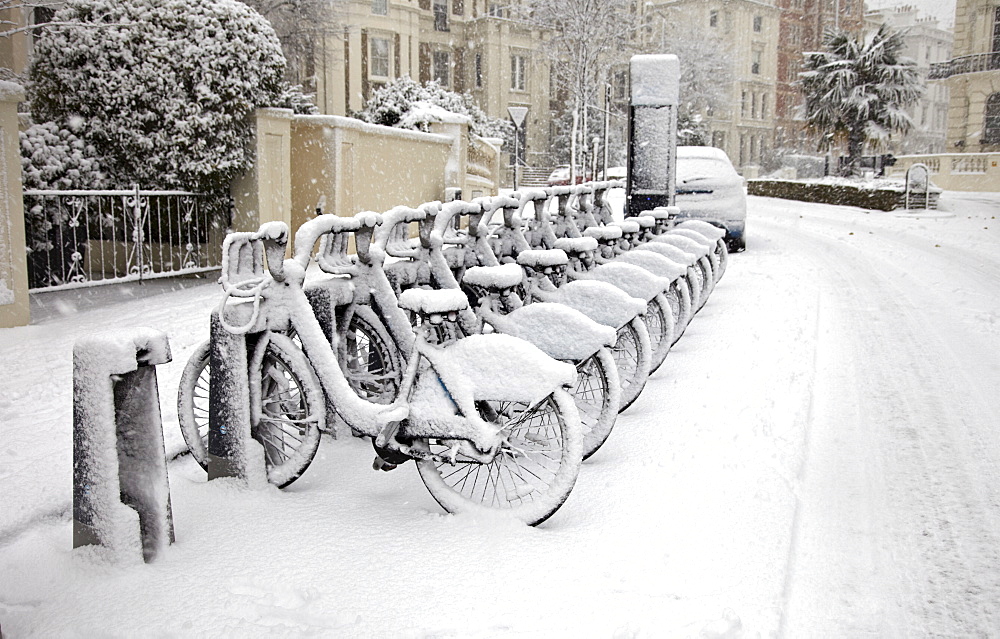 Rows of hire bikes in snow, Notting Hill, London, England, United Kingdom, Europe