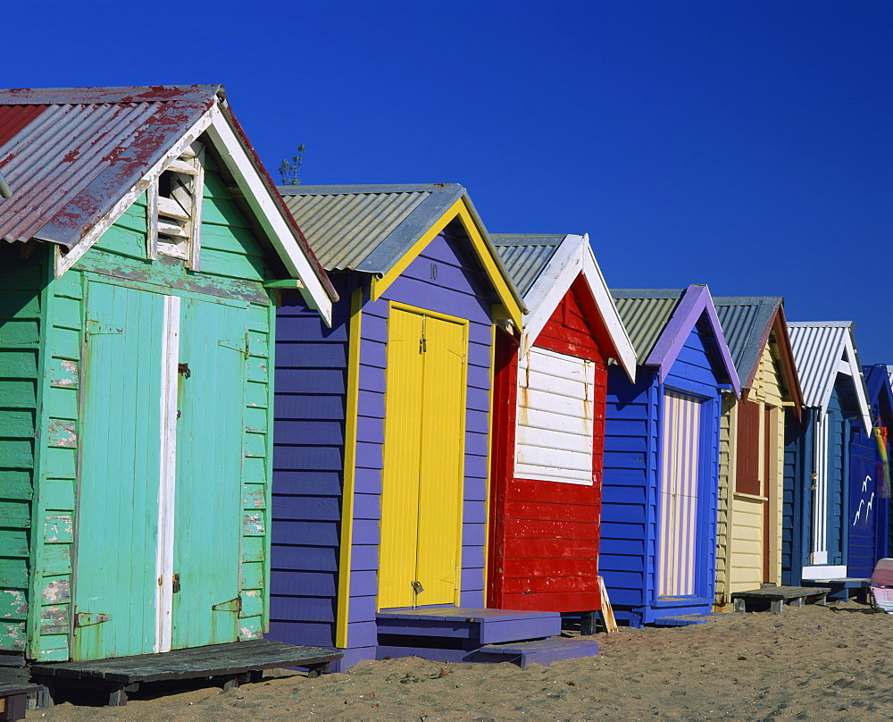 Exterior of a row of beach huts painted in bright primary colours, Brighton Beach, near Melbourne, Victoria, Australia, Pacific