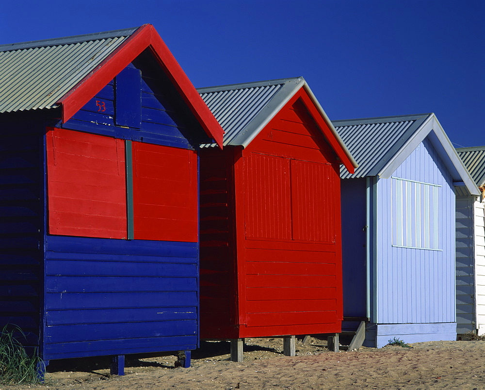 Brightly painted red and blue wooden beach bathing huts, Brighton Beach, near Melbourne, Victoria, Australia, Pacific