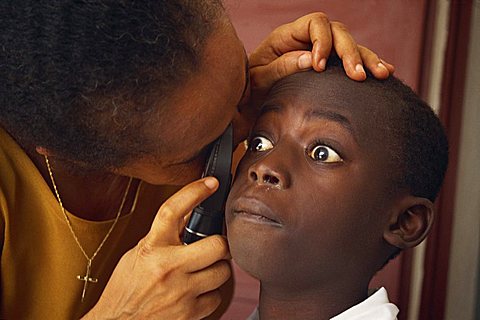 Doctor checking boy's eyes, Gambia, West Africa, Africa