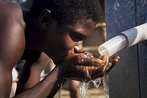 Teenage boy drinking from new UNICEF well, Vahun, Liberia, West Africa, Africa