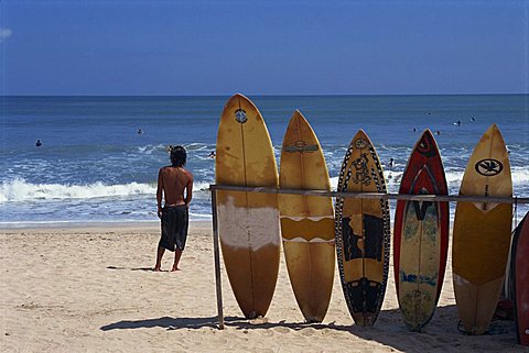 A line of surfboards waiting for hire at Kuta beach on the island of Bali, Indonesia, Southeast Asia, Asia