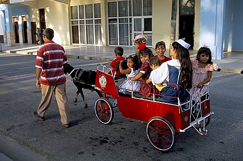 Goat cart with children on a Sunday in the Plaza de la Revolucion, Bayamo, Cuba, West Indies, Central America