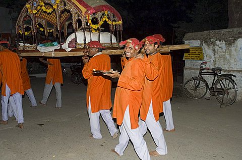 Men carrying a palaquin with the portrait of one of India's most celebrated 18th century female rulers, Ahilya Bai Holkar, during a Hindu ceremony, Maheshwar, Madhya Pradesh state, India, Asia