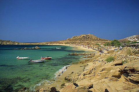 Rocky coastline with boats offshore at Piranga Beach, Mykonos, Cyclades Islands, Greek Islands, Greece, Europe