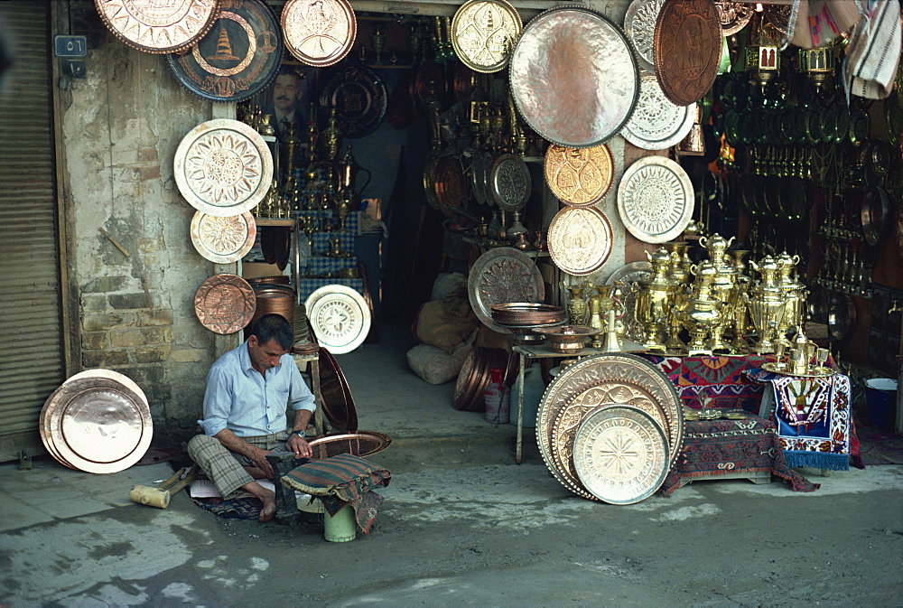 Man working on copper plate outside a copper souk, Baghdad, Iraq, Middle East