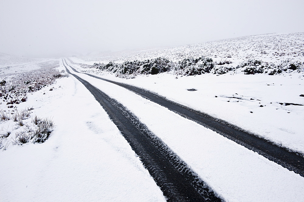 Car tyre tracks on a snowy road on the Mynydd Epynt moorland, Powys, Wales, United Kingdom, Europe