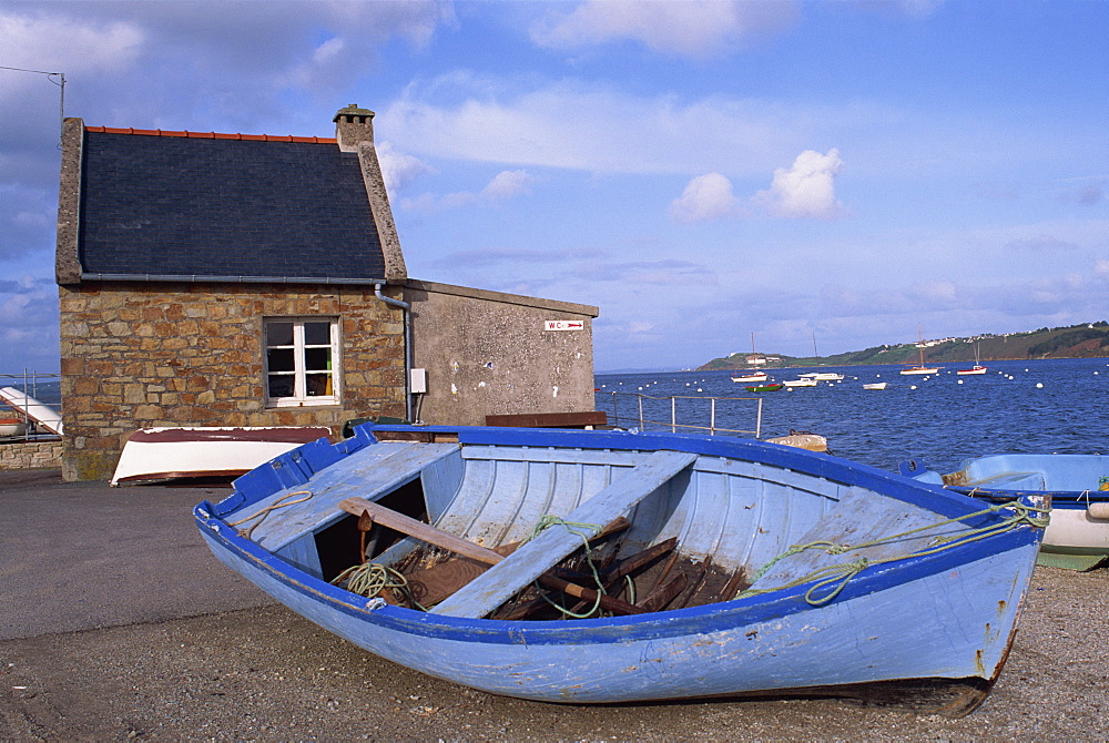 Blue boat on shore with the harbour of Le Fret behind, Brittany, France, Europe