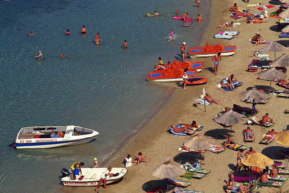 Aerial view over boats and people on a crowded beach on the main beach at Lindos Town, Rhodes, Dodecanese Islands, Greek Islands, Greece, Europe