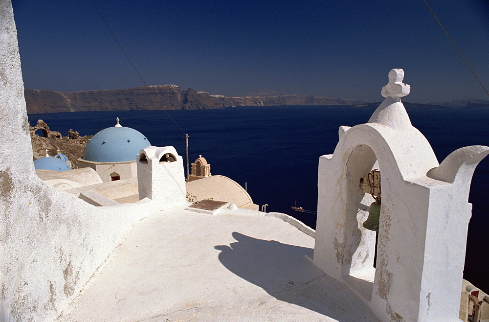 Exterior of Christian church bell tower and blue dome, in the village of Oia on the coast, Santorini (Thira), Cyclades Islands, Greek Islands, Greece, Europe