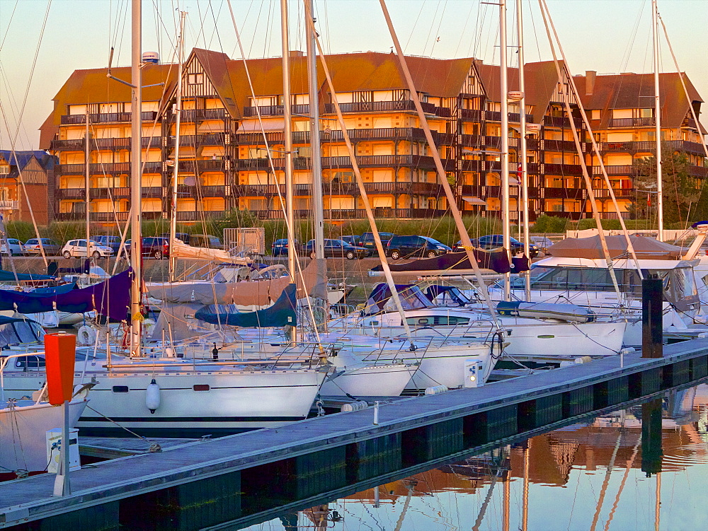 Floating quay and pleasure boats, with contemporary flats in Norman style in the background, at sunset, Port Deauville, Deauville, Calvados, Normandy, France, Europe