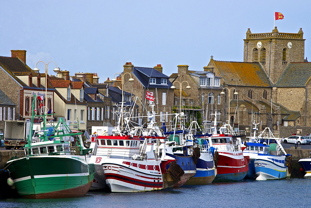 Fishing boats and harbour, and 17th century church in the background, Barfleur, one of the loveliest French village, Cotentin, Normandy, France, Europe