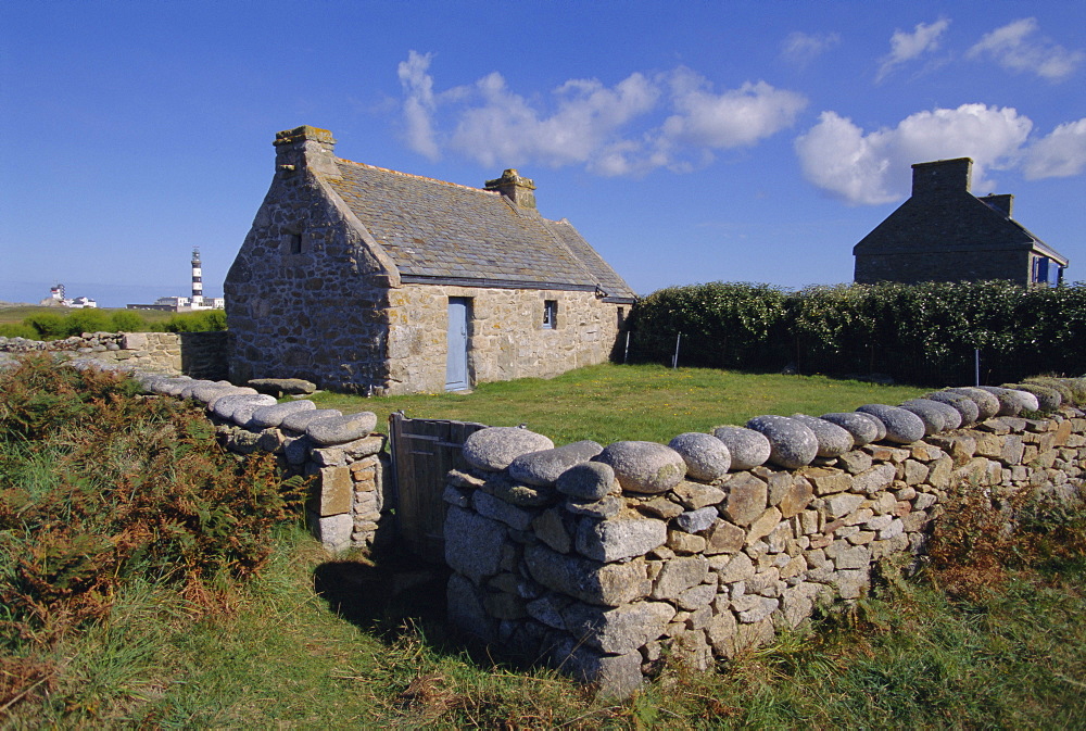 Ancient house with Creac'h lighthouse behind on Ouessant Island, Brittany, France, Europe