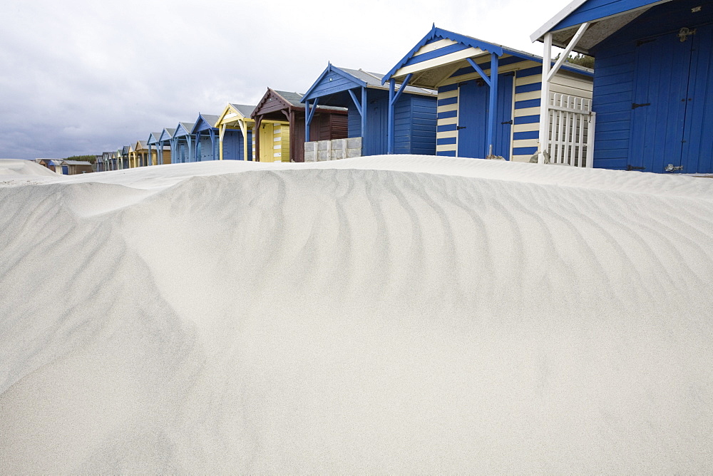 Beach huts in sand drift, West Wittering, West Sussex, England, United Kingdom, Europe