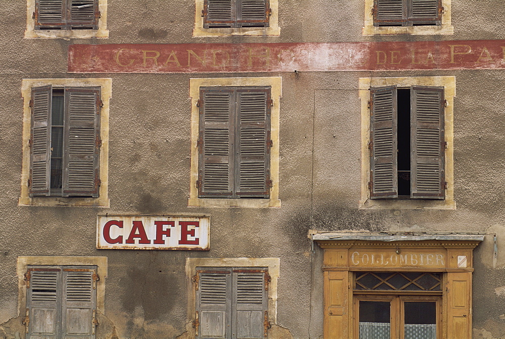 Cafe sign on the outside of an old hotel building with wooden shutters at Mauriac in the Auvergne, France, Europe