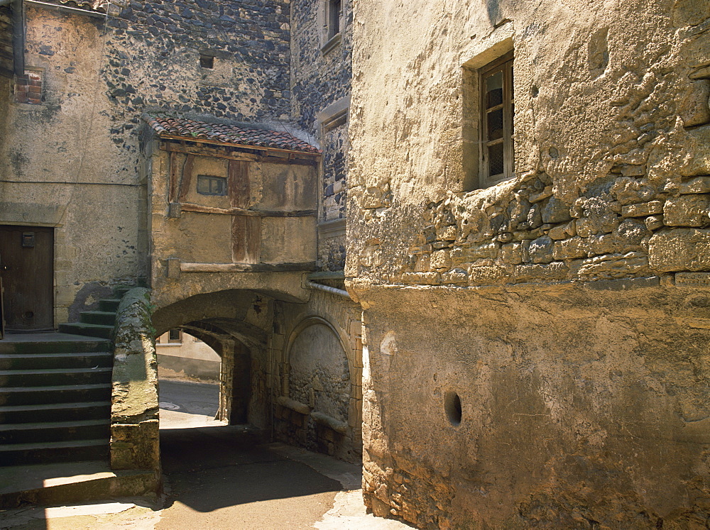 Exterior of village houses and arch on a street in St. Saturnin in the Auvergne, France, Europe