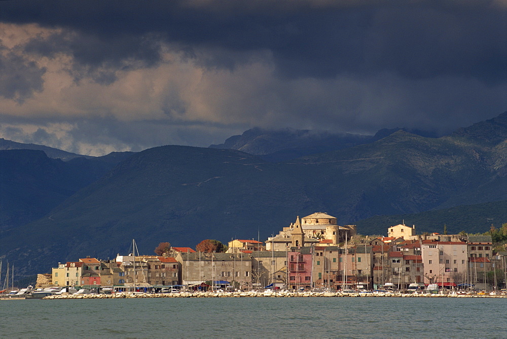 Dark clouds over hills and the skyline of the town of St. Florent on Cap Corse on the island of Corsica, France, Mediterranean, Europe